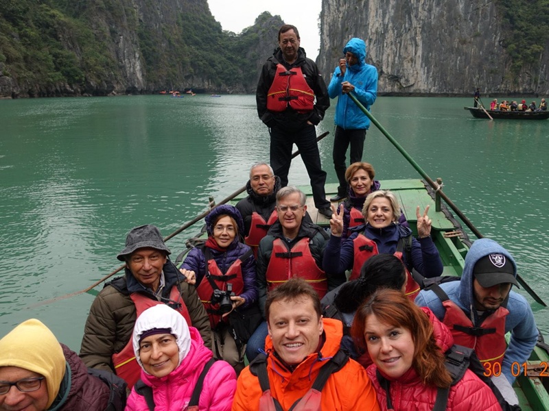 Halong körfezinde sandal ile gezinti yapan turist grubu